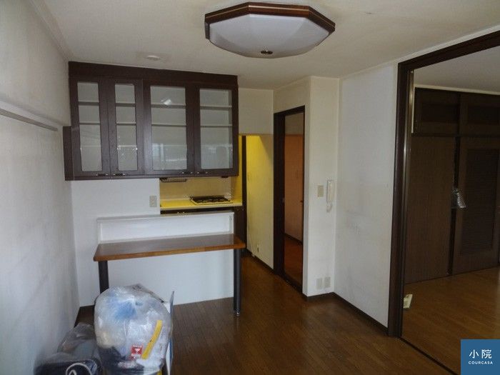 原屋況，廚房在半身高隔間牆後方，還有咖啡色上櫃阻隔視線。